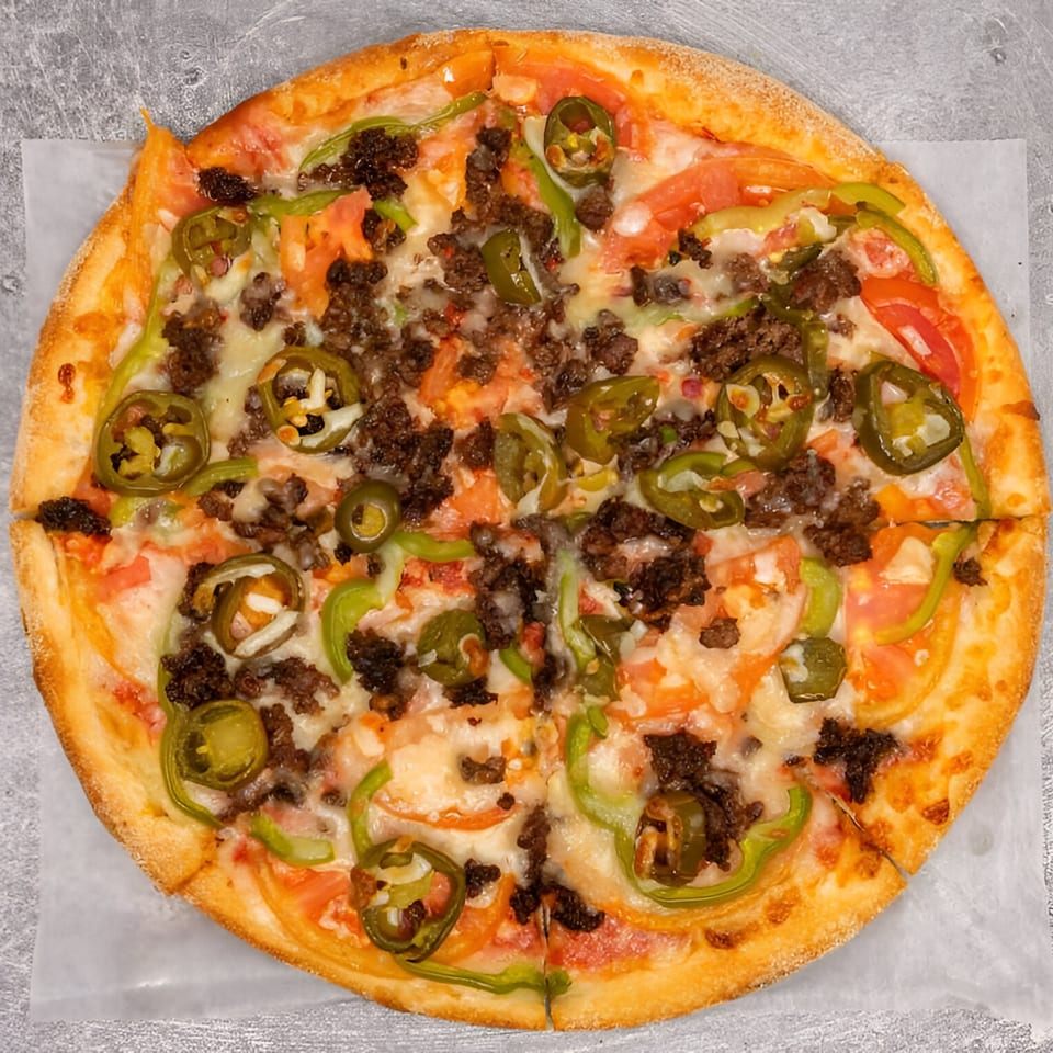 Halal pizza topped with ground meat, sliced tomatoes, green peppers, and jalapeños.