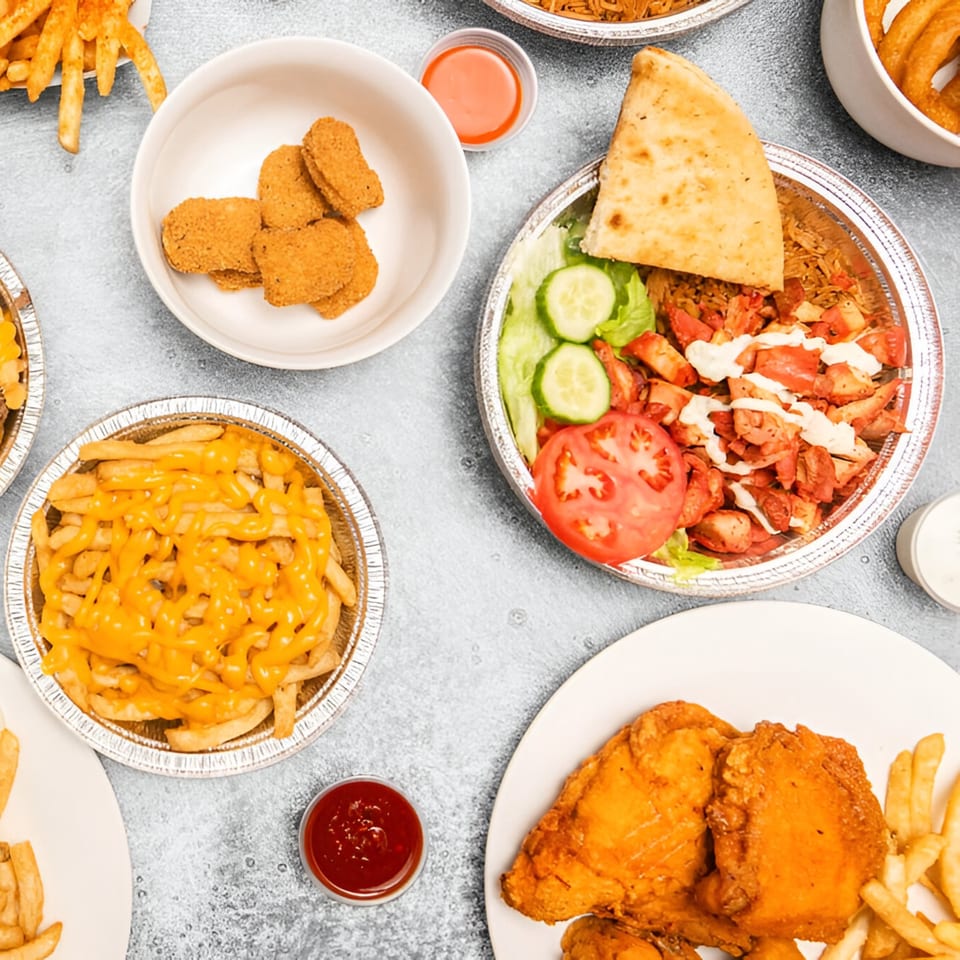 Overhead view of Kebabish Grill's fried chicken, cheesy fries, nuggets, and chicken kebab platter.