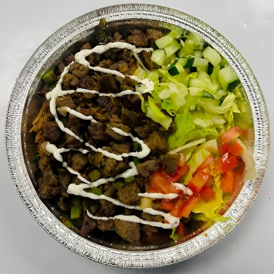 Kebabish Grill & Fried Chicken's halal platter with meat, lettuce, cucumbers, tomatoes, and white sauce.